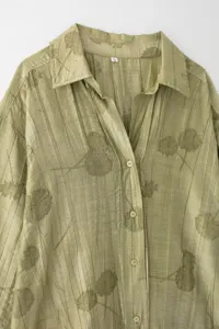 Gros plan détaillé du col de chemise en jacquard vert clair avec une belle patte de boutonnage.