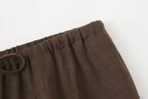 Close-up detail of dark brown linen garment waistband with elastic and drawstring.