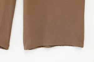 Brown trousers pants hem fabric detail view close up apparel fashion casual style.