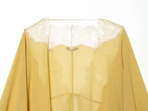 Chiffon lace cardigan detail shot showcasing delicate floral lace trim and lightweight yellow fabric.