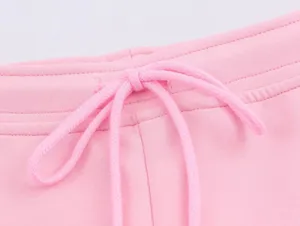 Detail cordon jogging rose gros plan, tissu maille douce ceinture sport style.