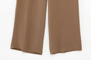 Brown wide-leg trousers pant leg detail shot, casual draping fabric texture close up view.