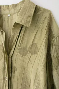 Vue détaillée de la chemise à manches longues vert olive avec boutons, motif floral et col.