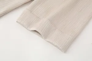 Primer plano detallado de prenda plisada para mujer con textura fina y diseño de puño limpio.