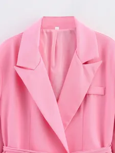 Détail de veste blazer rose, design de col à revers élégant, style professionnel.