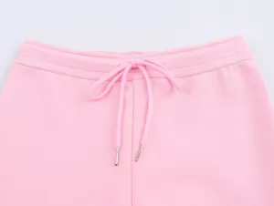 Gros plan sur la taille élastique d'un pantalon de survêtement rose avec cordon.