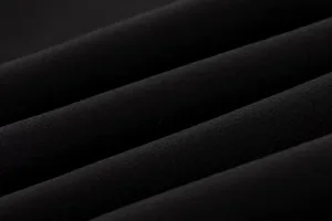 Close-up detail of smooth black fabric with elegant folds, showing high-quality texture.