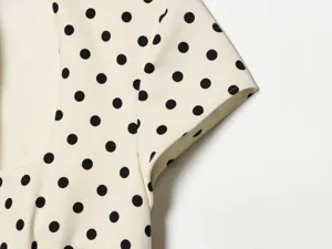 Detaillierte Ansicht des französischen Polka-Dot-Kleides, elegante kurze Ärmel Stoff Textur nah.