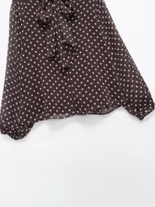 Detailed shot of elegant brown polka dot long sleeve blouse with stylish neck tie bow.