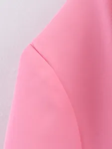 Gros plan détaillé de la couture d'épaule et texture du blazer en mélange de lin rose.
