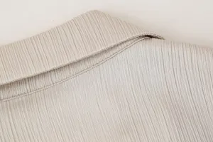 Detalle de cuello de blazer plisado para mujer, tela texturizada elegante de primavera.