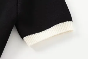 Feines Strick-Kurzarm-Kleidungsstück Detail Nahaufnahme mit kontrastfarbenem Rippbündchen.