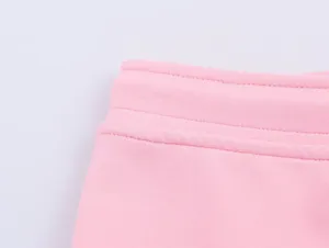 Pantalon sport rose taille élastique détail gros plan, tissu confortable doux.