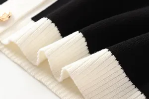 Nahaufnahme des schwarz-weißen Kontrast-Strickstoffs mit luxuriösem goldenem Knopf.