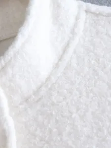 White fleece jacket detail closeup, soft sherpa fabric collar texture, cozy winter outerwear.