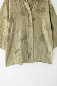 Vue detaillee de la chemise vert olive avec des imprimees botaniques et plis delicats.