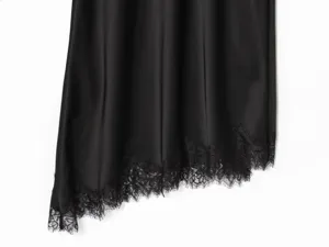 Black satin slip dress detail with exquisite lace trim, elegant asymmetrical hem fabric closeup.