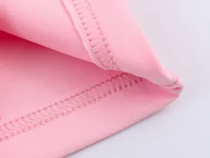 Vue detaille de la couture du tissu rose et des finitions pour vetement de sport.