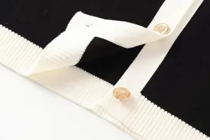 Schwarzer und weißer Kontrast Strickjacke Detail mit edlen goldenen geprägten Knöpfen.