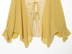 Close-up detail of french lace spliced chiffon cardigan sleeve and front tie design.