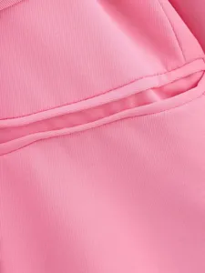Gros plan sur le tissu d'un blazer pour femme rose vif avec une texture et couture.