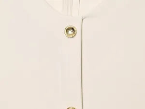 Detail view of elegant beige dress featuring gold-toned metal buttons and round neckline.