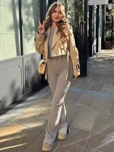 Detailed street style view of a stylish short trench coat paired with casual outfit.