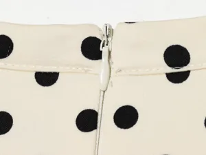 Polka-Dot-Kleid Reißverschluss Detail zeigt Stoff und Verschluss für Damenbekleidung.