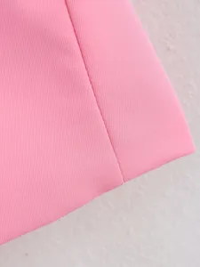 Vue rapprochée détaillée du tissu rose et des coutures soignées pour blazer de femme.