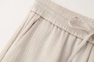 Vista detallada de pantalones casuales plisados de mujer con cintura de cordón.