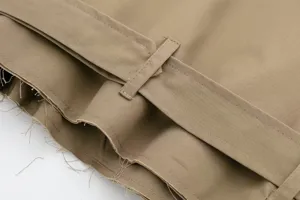Close up detail of women khaki short trench coat raw hem belt loop fashion clothing