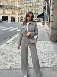 Vue détaillée de l'ensemble tailleur pantalon gris élégant porté en décor de rue européenne.