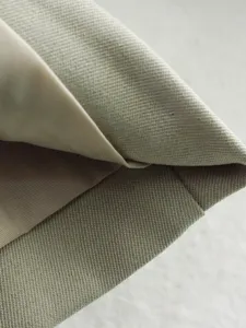 Vue détaillée de la texture du tissu de pantalon de costume pour femme avec armure sergée et doublure.
