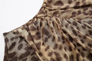 Close-up detail of women's leopard print sheer mesh fabric with stylish ruched design.