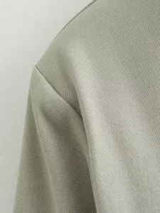 Gros plan sur un tissu de costume gris-vert de qualité avec une texture twill fine.