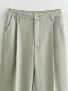 Gros plan sur les détails de ce pantalon de costume femme taille haute avec plis.