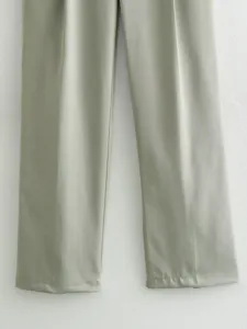 Gros plan détaillé du pantalon de costume vert casual, montrant le tissu et l'ourlet.