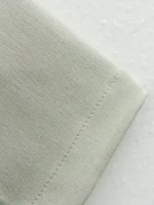 Gros plan détaillé de tissu de costume vert clair avec texture fine et belle couture.