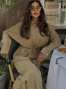 Chic khaki long sleeve top and wide leg pants set detail, elegant casual style in a cafe scene.