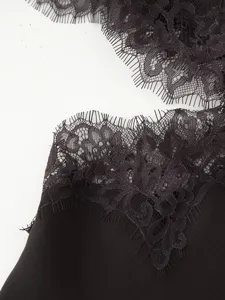 Close-up detail of black women's dress with exquisite lace trim and delicate floral patterns.