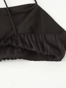 Black mesh dress detail showing ruched elastic waistband and delicate fabric texture.