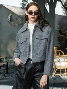 Detail view of grey tweed short jacket, featuring front zipper and lapel design for women.