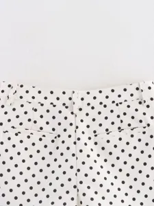 Vista detallada de pantalones cortos de lunares para mujer con presillas y bolsillos.