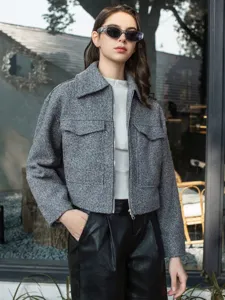 Detail view of women's grey tweed short jacket, featuring lapel collar and zipper closure style.