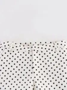 Detalle de la cintura del pantalón corto de lunares blancos y negros, moda verano.