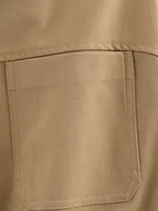 Close-up detail of khaki twill fabric garment pocket with fine stitching craftsmanship.