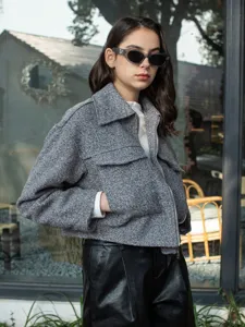 Grey tweed short jacket detail featuring stylish lapel, metal zipper, and chest pockets.