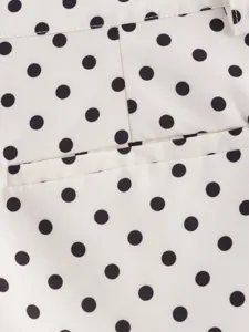 Primer plano de los detalles de tela de lunares blancos y negros con bolsillo y pretina.