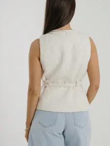 Back view detail of beige textured sleeveless tweed vest with stylish waist belt for women.