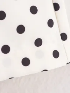 Primer plano detallado del tejido clásico de lunares en blanco y negro con costuras.